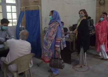 People wait to receive doses of the Chinese-made Sinopharm vaccine, at a vaccination centre in Karachi on March 26, 2021.