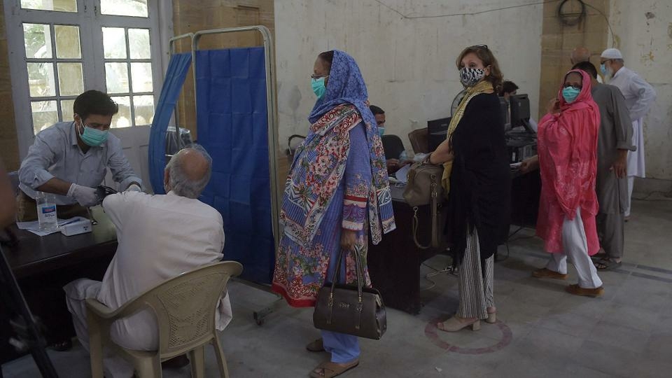 People wait to receive doses of the Chinese-made Sinopharm vaccine, at a vaccination centre in Karachi on March 26, 2021.