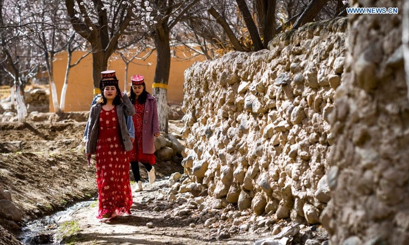 Villagers walk on a road in Bageaigezi Villge of Akto County, northwest China's Xinjiang Uygur Autonomous Region, March 31, 2021. Local farmers and herdsmen in the mountainous area of Pamirs have seen their life turning better with the development of tourism and the improvement of infrastructure.  Photo: Xinhua