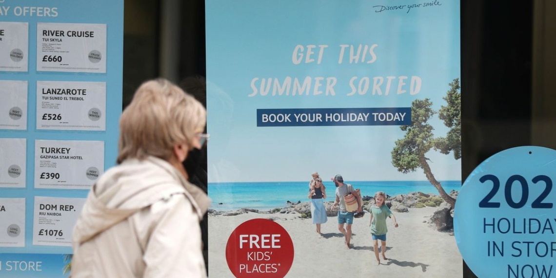 A person makes their way past the shop window of a Tui store in Eastleigh, Hampshire