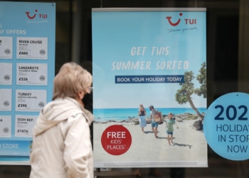 A person makes their way past the shop window of a Tui store in Eastleigh, Hampshire