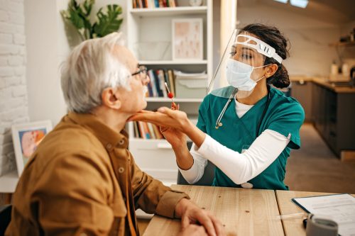 A doctor performing a nasal swab for a COVID test on a senior man