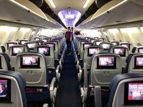 Delta airplane airplane interior with person deplaning.