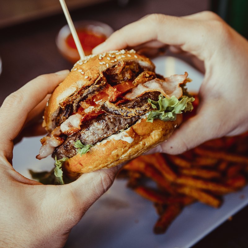 hands holding eaten burger