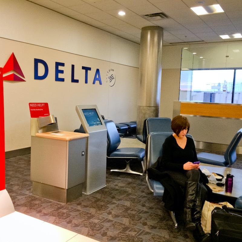 woman waiting at delta counter - Travel News, Insights & Resources.