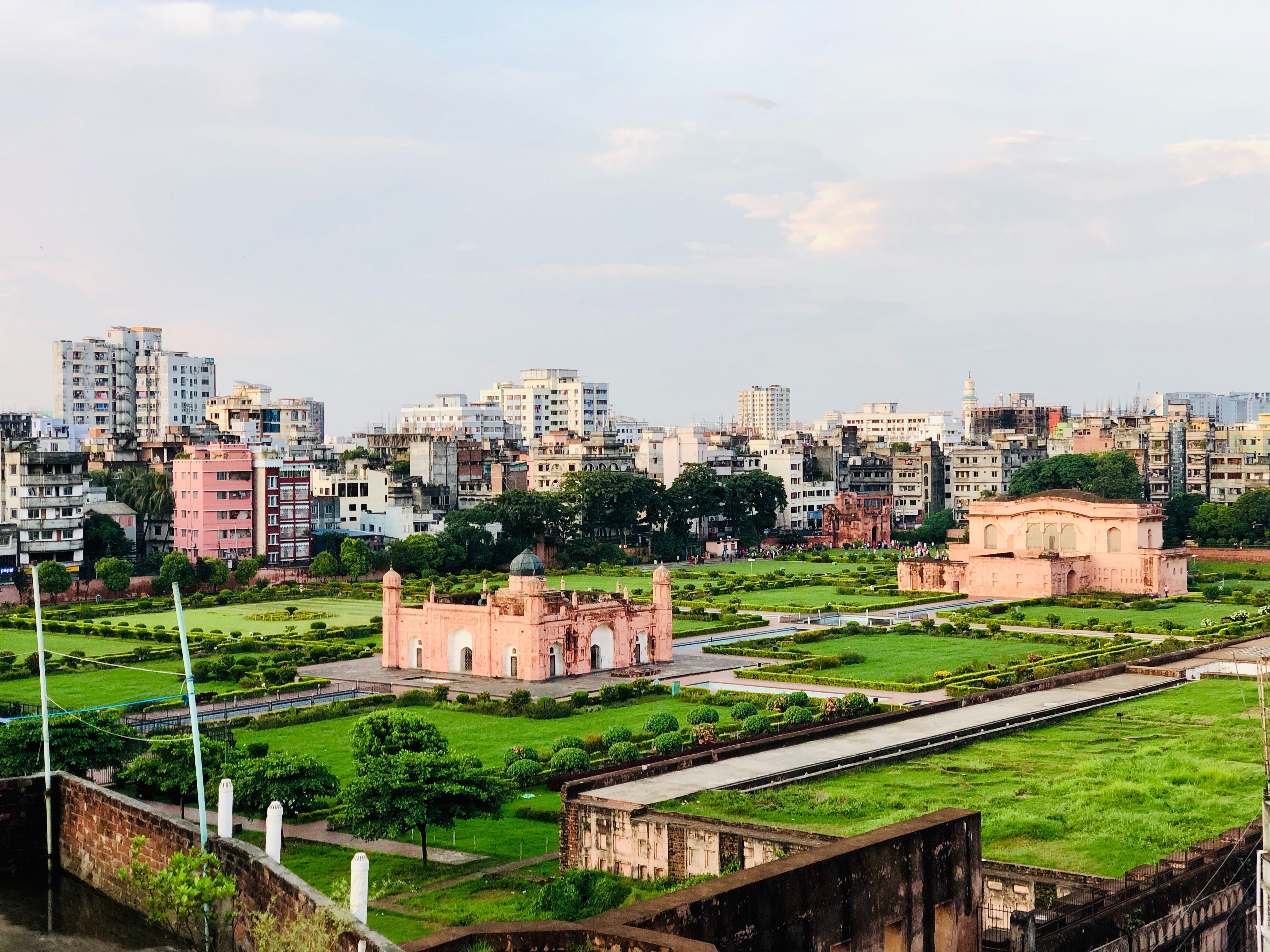 historic buildings surrounded by green lawn and concrete structures 