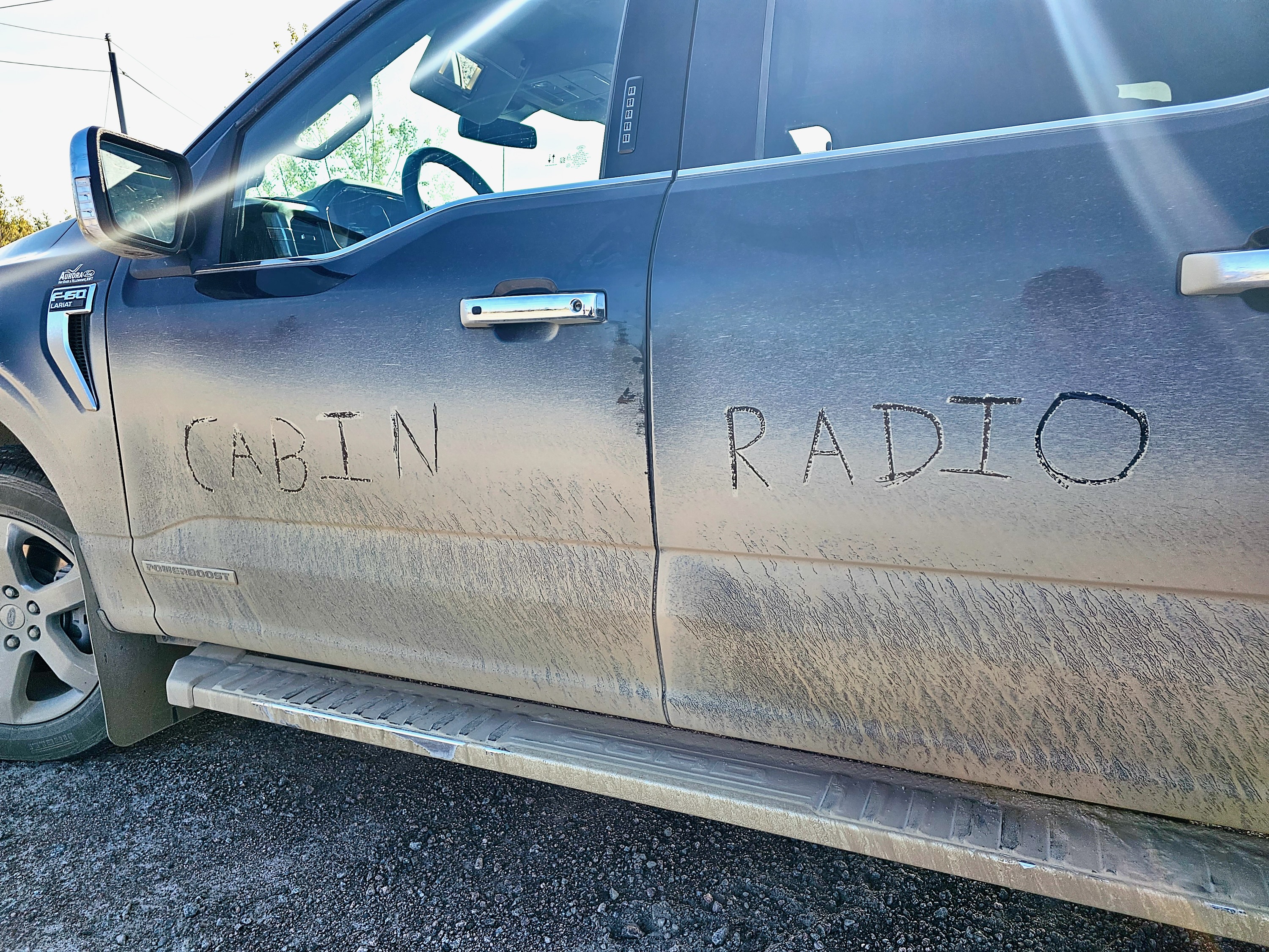 "Cabin Radio" appears on the side of a truck after a drive through the Dehcho in summer. Ollie Williams/Cabin Radio