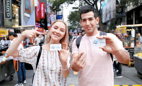 Foreig tourists to Korea hold up their Korea Tour Card during their visit to Seoul's Myeongdong last summer [JOONGANG ILBO] 