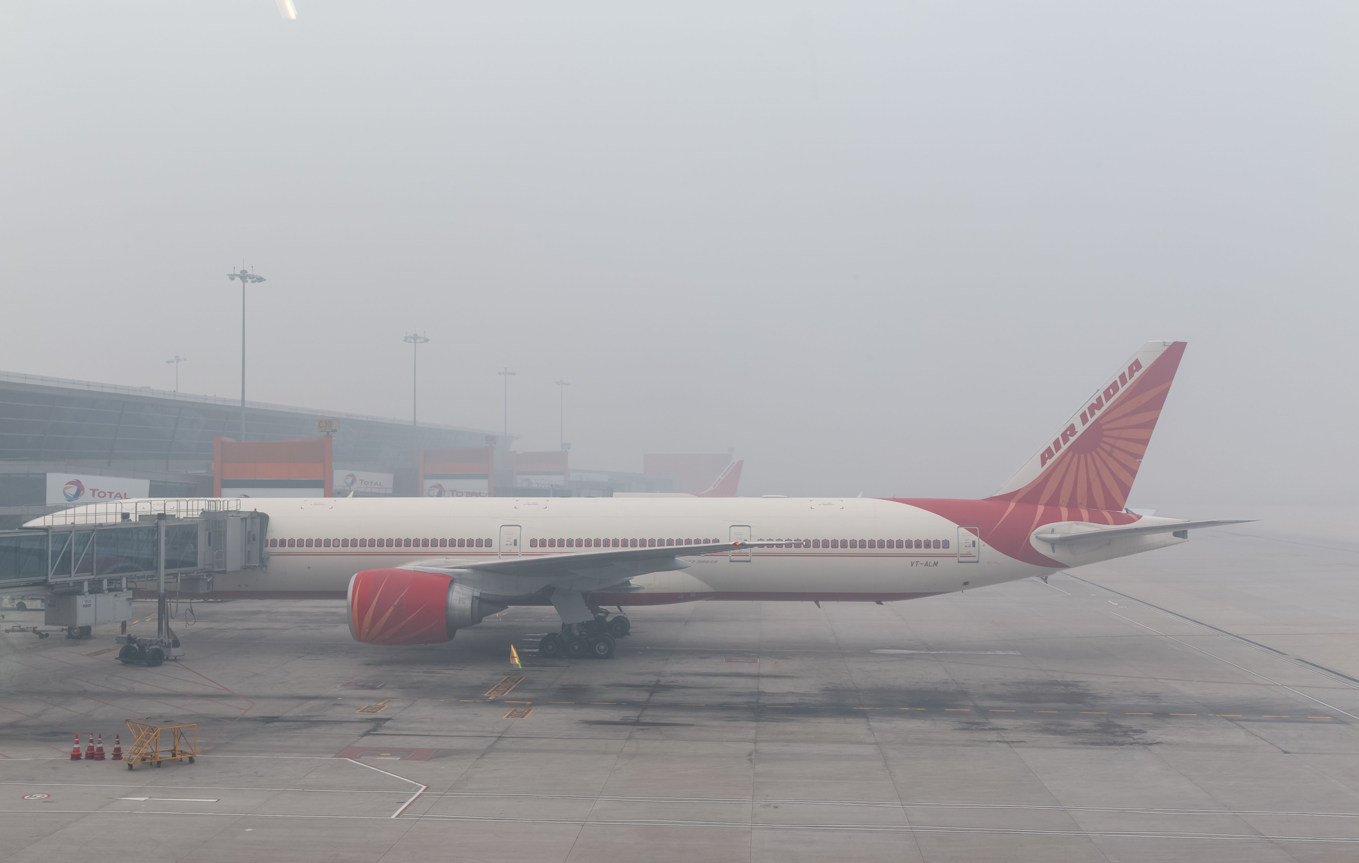 Landscape view of aircrafts or plane standing on Airport during winter fog to carry the passengers. (Air India Boeing 777)