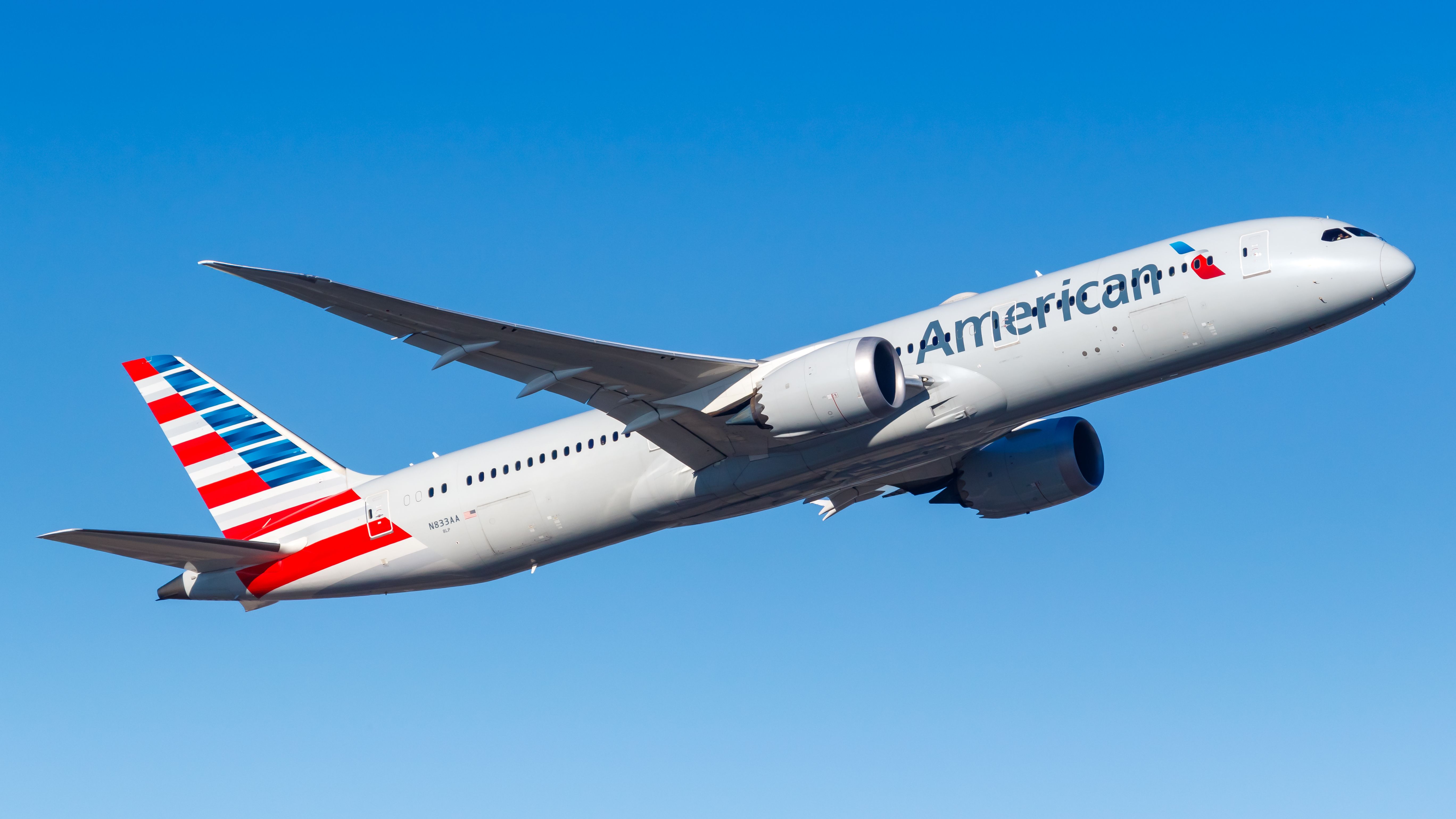 An American Airlines Boeing 787-9 flying in the sky.