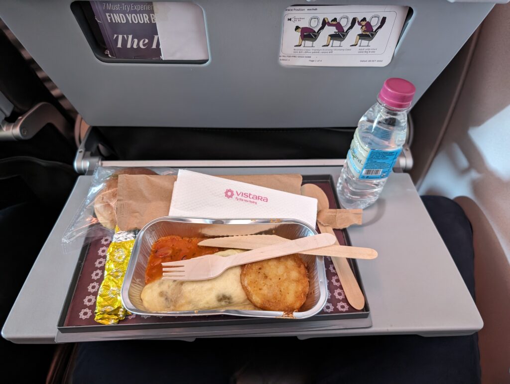 An omelet is served inflight and displayed with a bottle of water.