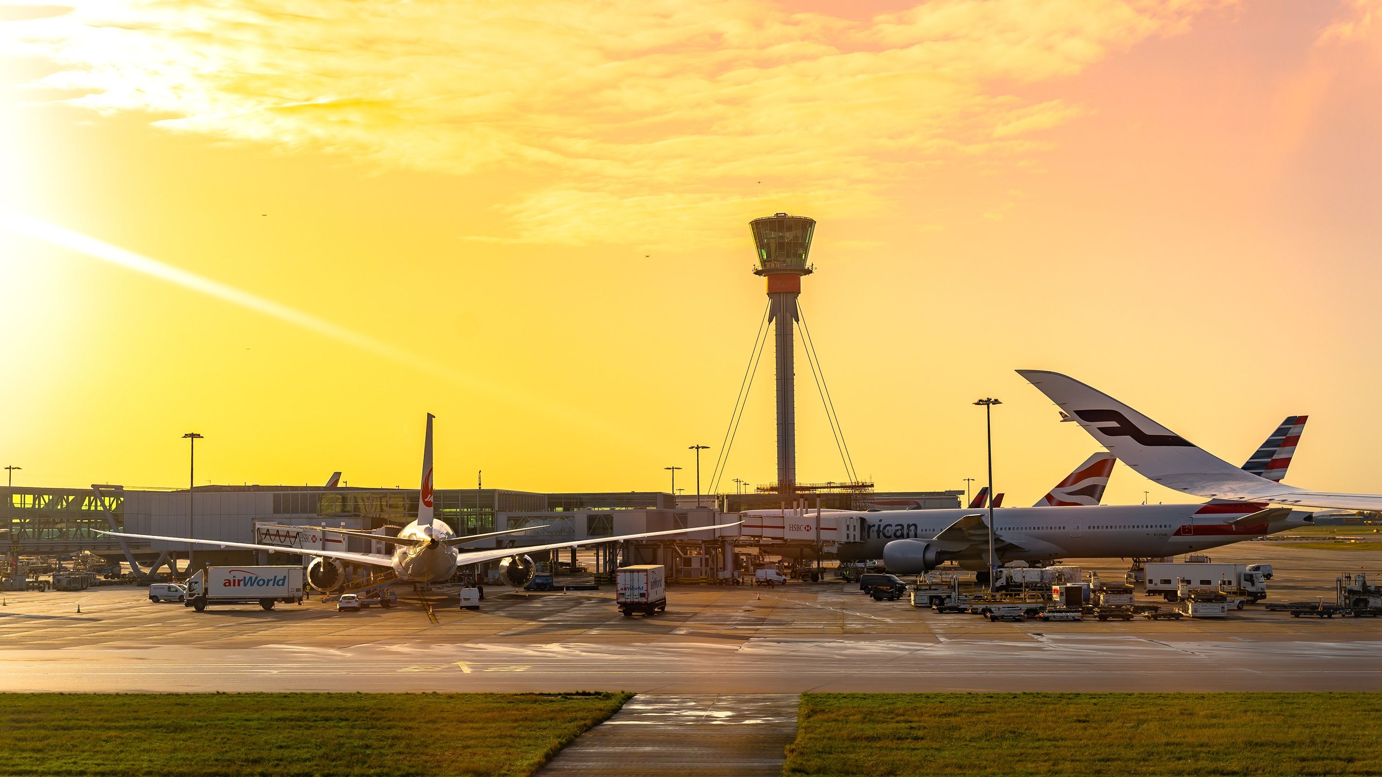 American Airlines, British Airways, and Finnair aircraft on the apron at London Heathrow Airport.