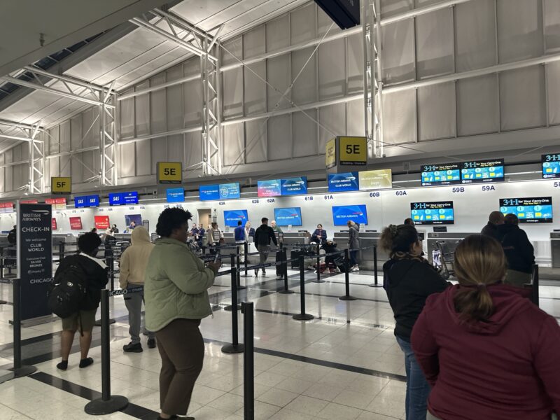 people in a terminal with several monitors