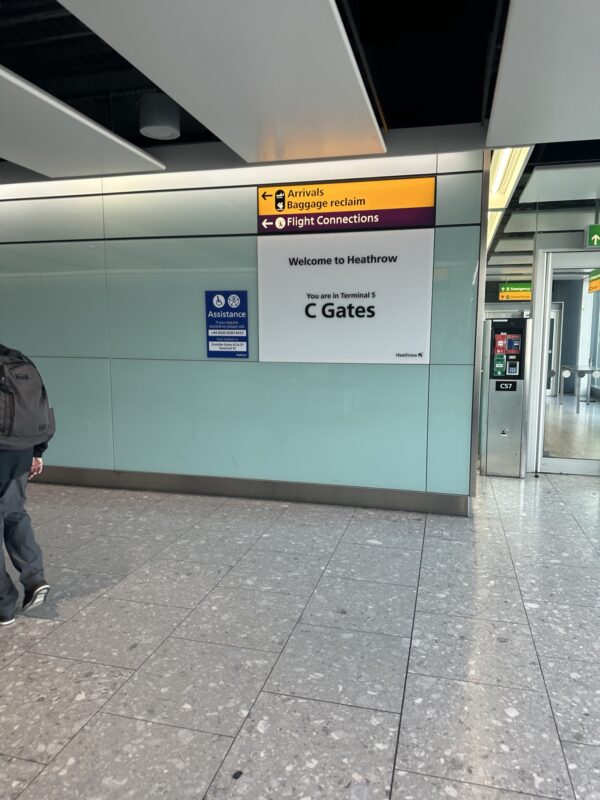 a man walking in a hallway with a sign on the wall