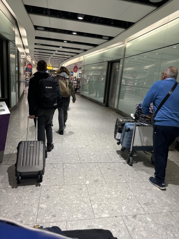 a group of people with luggage in a hallway