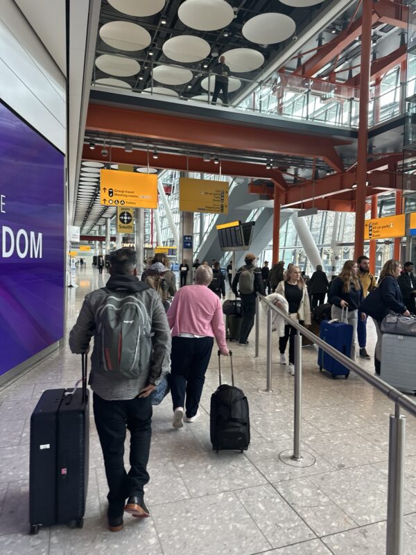 a group of people walking with luggage in an airport