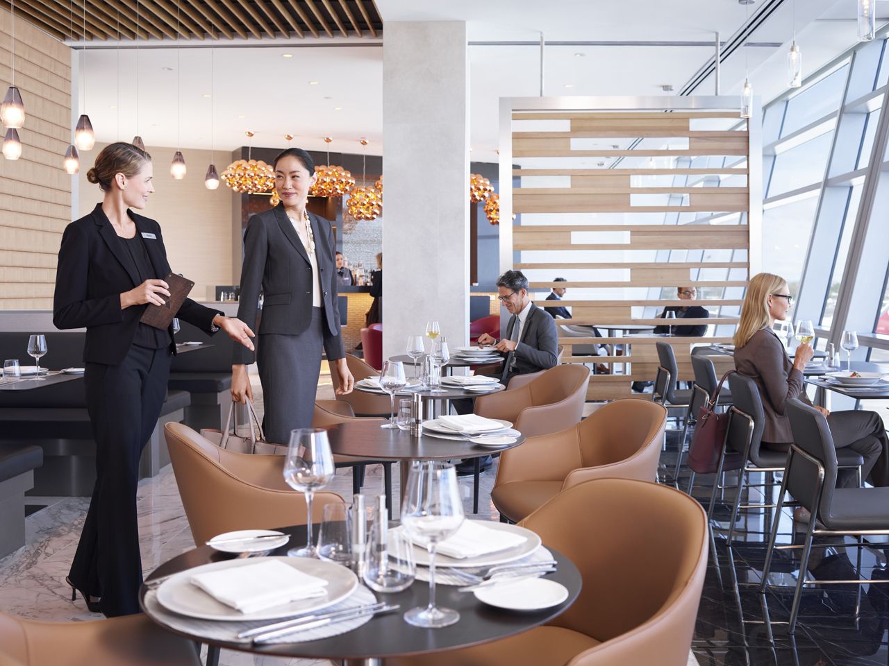 Several passengers inside an American Airlines Admirals Lounge.