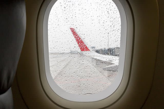 <p>zhongguo/Getty</p> Stock image of rain seen through an airplane window