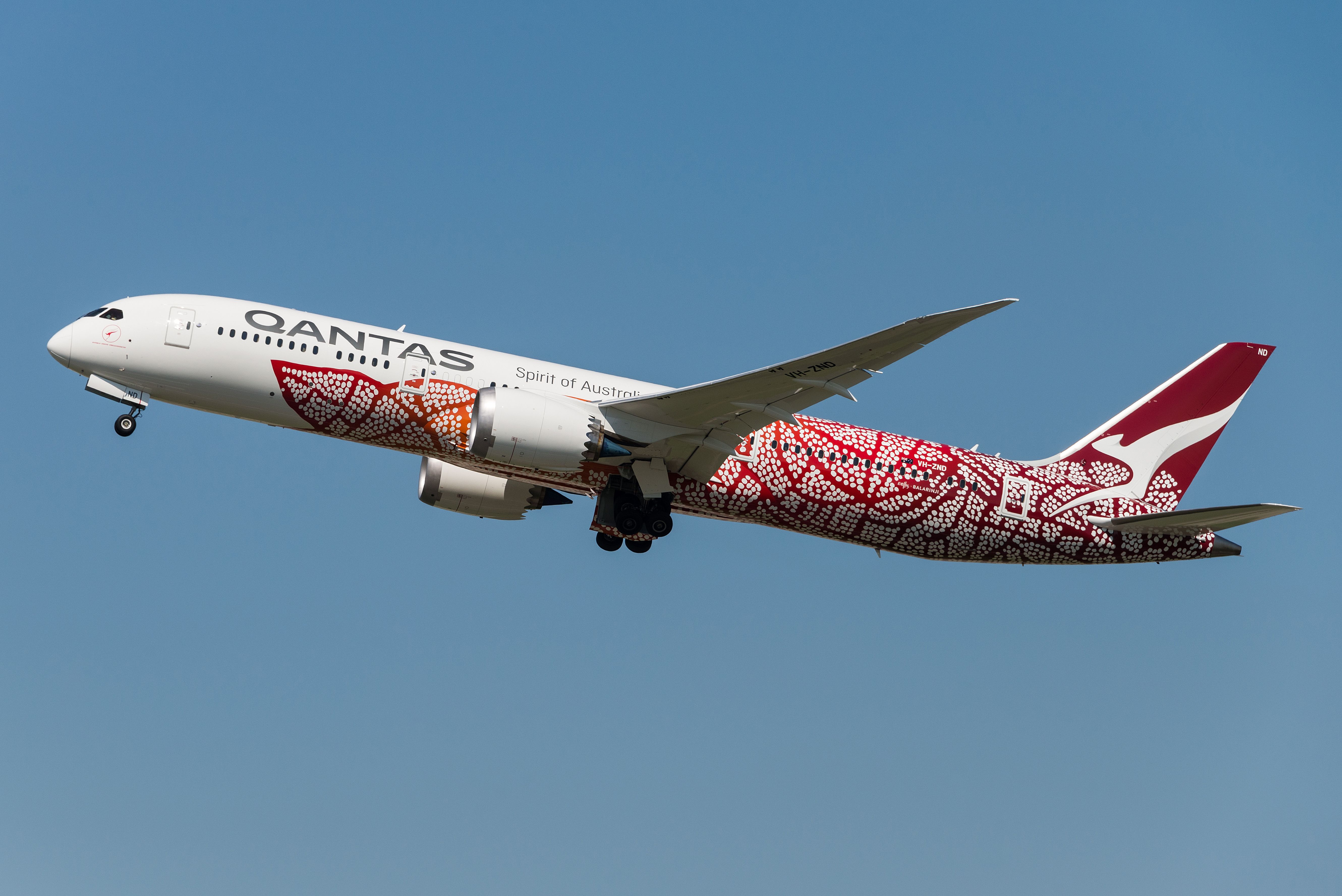 A Qantas Boeing 787 flying in the sky.